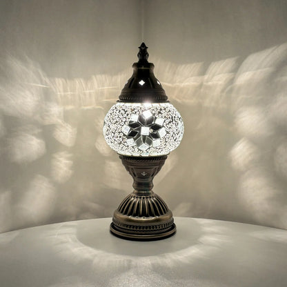 Decorative table lamp with mosaic design on a neutral background