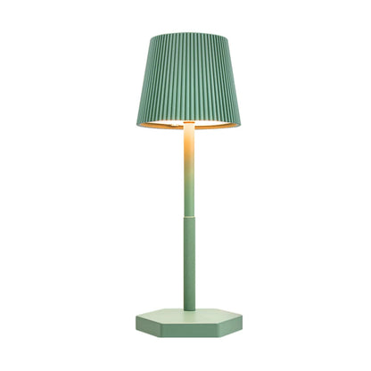 Green table lamp with a pleated shade on a white background